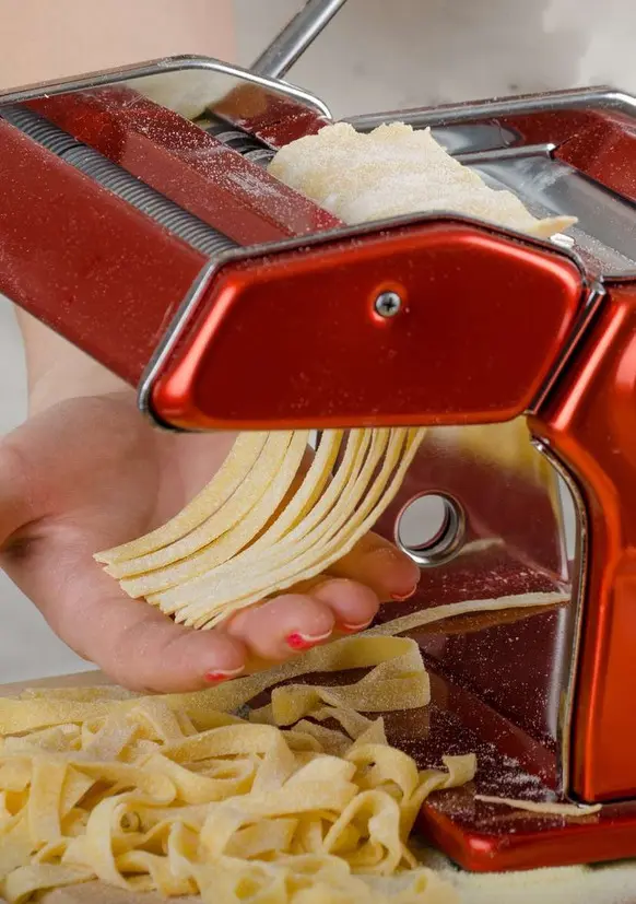 Fresh fettuccine coming off the pasta machine